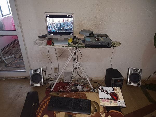 Escritorio improvisado con monitor y cables colgando
