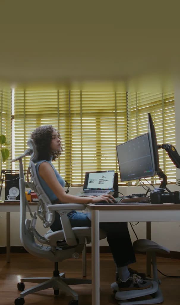 Persona usando una silla LiberNovo Omni frente a su escritorio